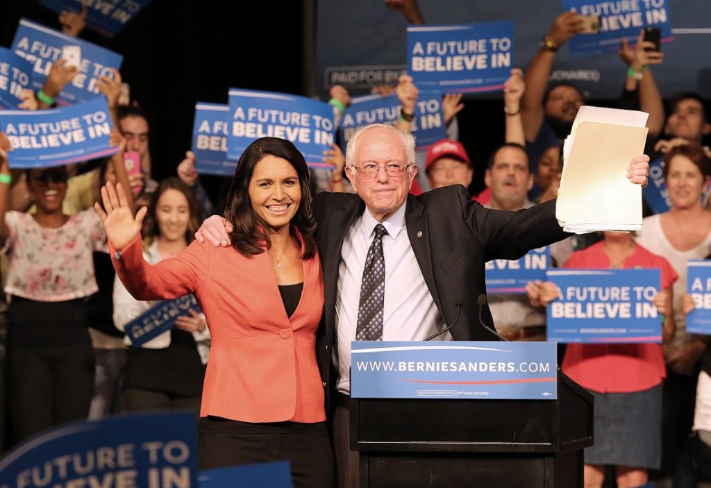 Rep. Tulsi Gabbard, D-Hawaii, and Democratic presidential candidate Sen. Bernie Sanders wave to supporters during a campaign event in Miami at the James L. Knight Center on Tuesday, March 8, 2016. (Pedro Portal/El Nuevo Herald/TNS via Getty Images)