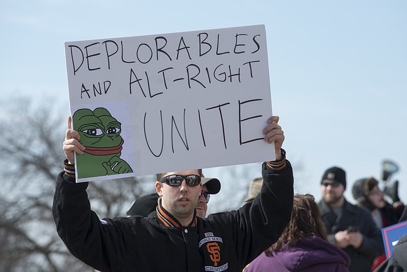 A Unite the Right rally attendee with a pepe meme poster. (Source: Wikimedia)