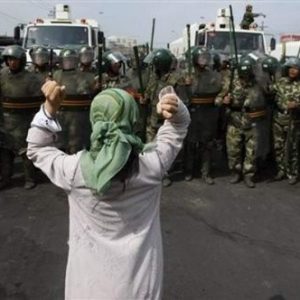 Uighur woman stands in opposition to Chinese military. Source: East Turkistan Australian Association 